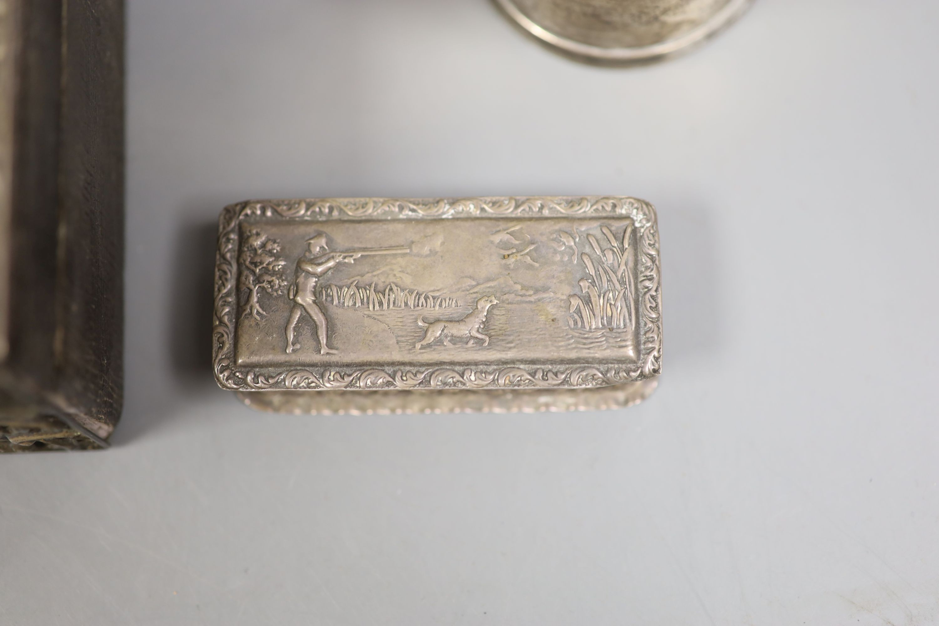 A late Victorian silver mounted leather rectangular jewellery casket, 23.2cm, a silver snuff box, the lid embossed with a wild fowling scene, a George V silver cream jug and pepper, two silver napkin rings and a Victoria